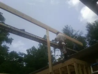 Carpenter setting a ridge beam over a new addition frame — Ice Dam Removal by Roofing Brothers in Lewellen