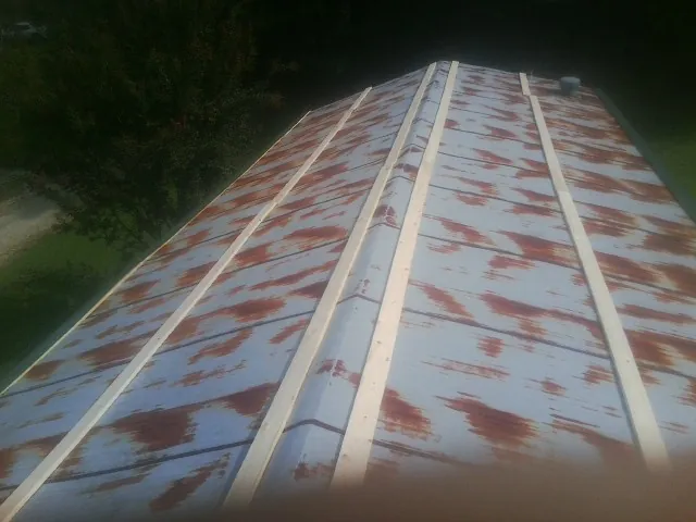Rusted metal roof panels with new wood purlins before replacement — Storm Damage Roof Repair in Lewellen by Roofing Brothers