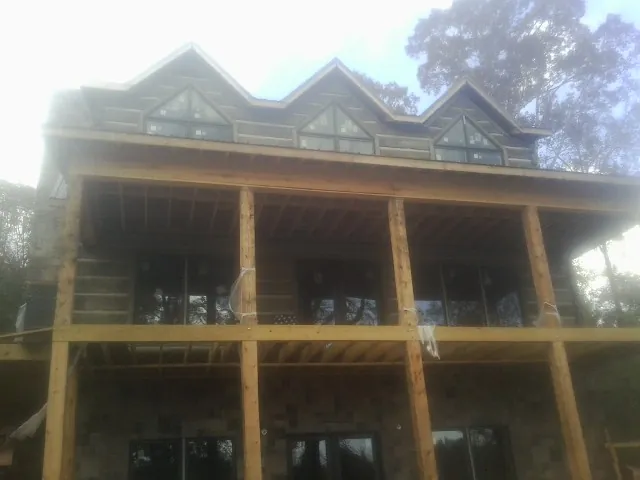 Dormers and porch framing on a large log home under construction — Roof Coating work by our crew in Lewellen